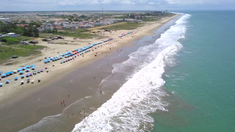 drone shot flying down over the beach in the town of playas general villamil, ecuador