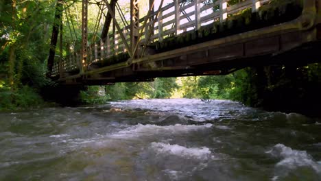 aerial fast pullout river in damascus virginia under iron railroad bridge