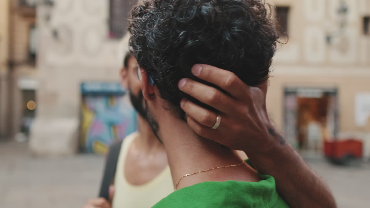 Coppia gay che condivide un momento affettuoso in una strada cittadina