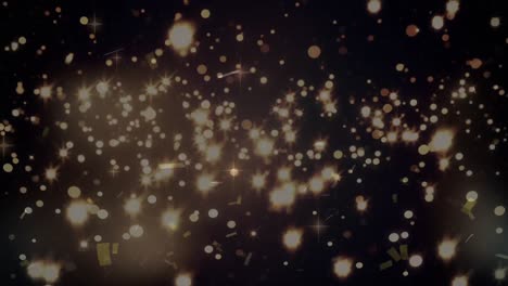 manchas brillantes de luz y confeti cayendo contra un fondo negro