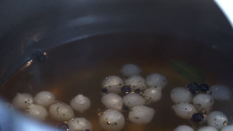 juniper berries and onions are cooked to make pickled cucumbers