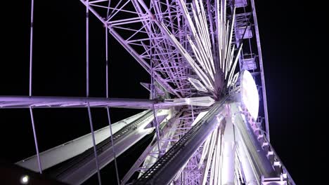 las luces de la rueda de ferris girando lentamente por la noche