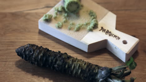 rizoma de wasabi fresco rallado en un rallador de piel de tiburón japonés