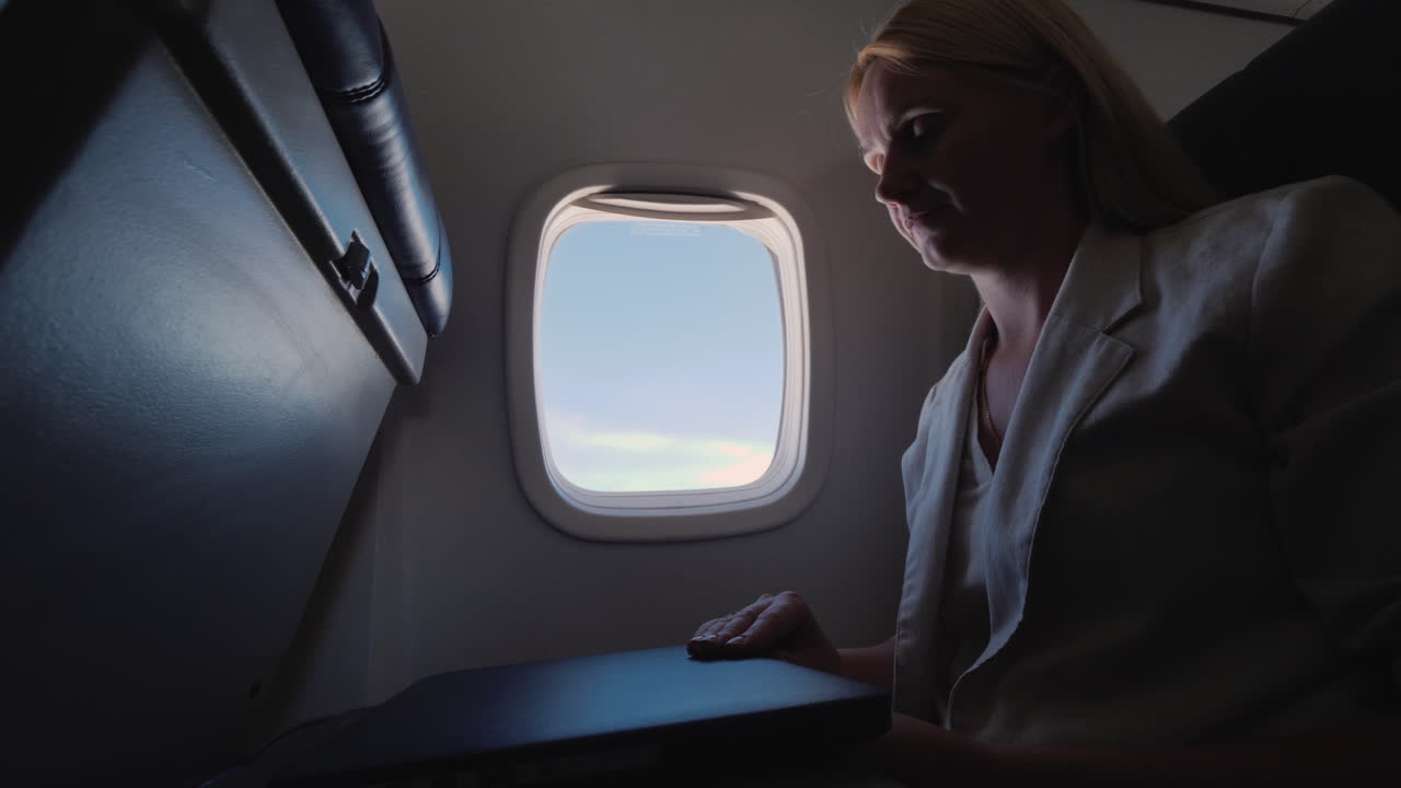 la mujer abre la computadora portátil en el concepto de viaje de negocios del avión