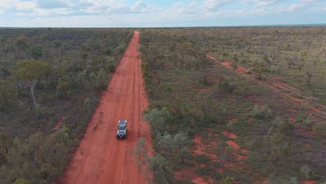 A-four-wheel-drive-car-driving-down-the-outback-desert-red-dirt-road