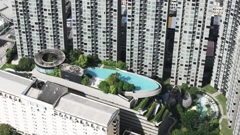 close up of big oval swimmingpool surrounded by tall buildings