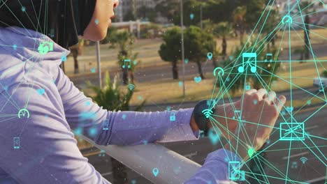 animation of network of connected media icons with woman wearing hijab using smartwatch