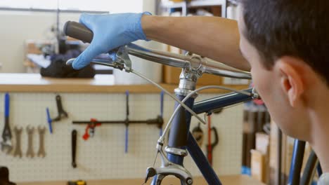 Man-repairing-bicycle-in-workshop-4k