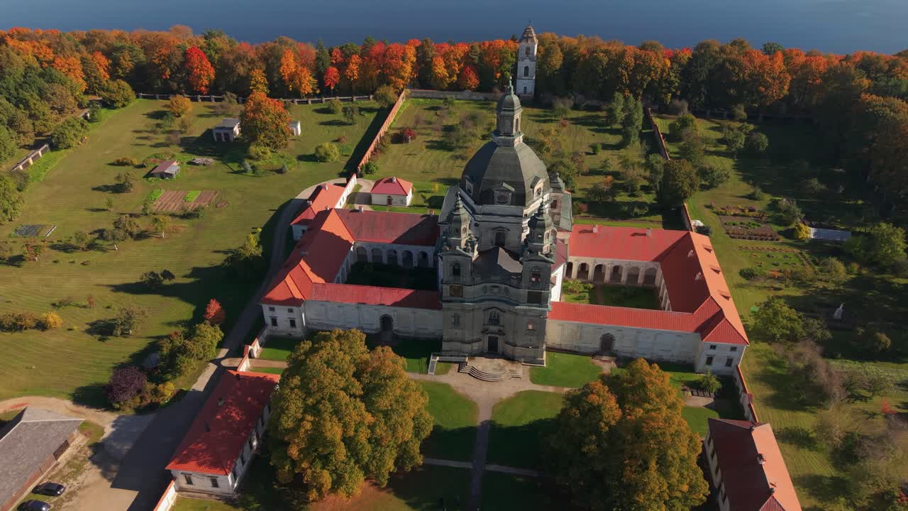 Aerial view of Pazaislis Monastery in Kaunas, Lithuania, surrounded by colorful autumn forest. A historic Baroque landmark and religious complex near the Kaunas Reservoir