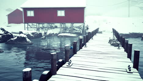 red cabin on a snowy dock in winter