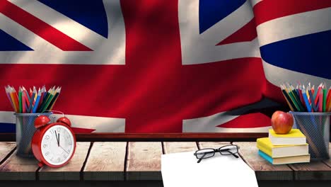 school accessories lying on a table with a british flag in the background