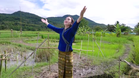 happy woman in traditional thai dress in a rice paddy