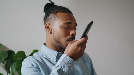 Contemporary-man-speaking-phone-at-home-closeup.-Guy-talking-mobile-speakerphone