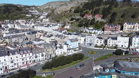 colourful llandudno seaside holiday town hotels against great orme mountain aerial view slow push in