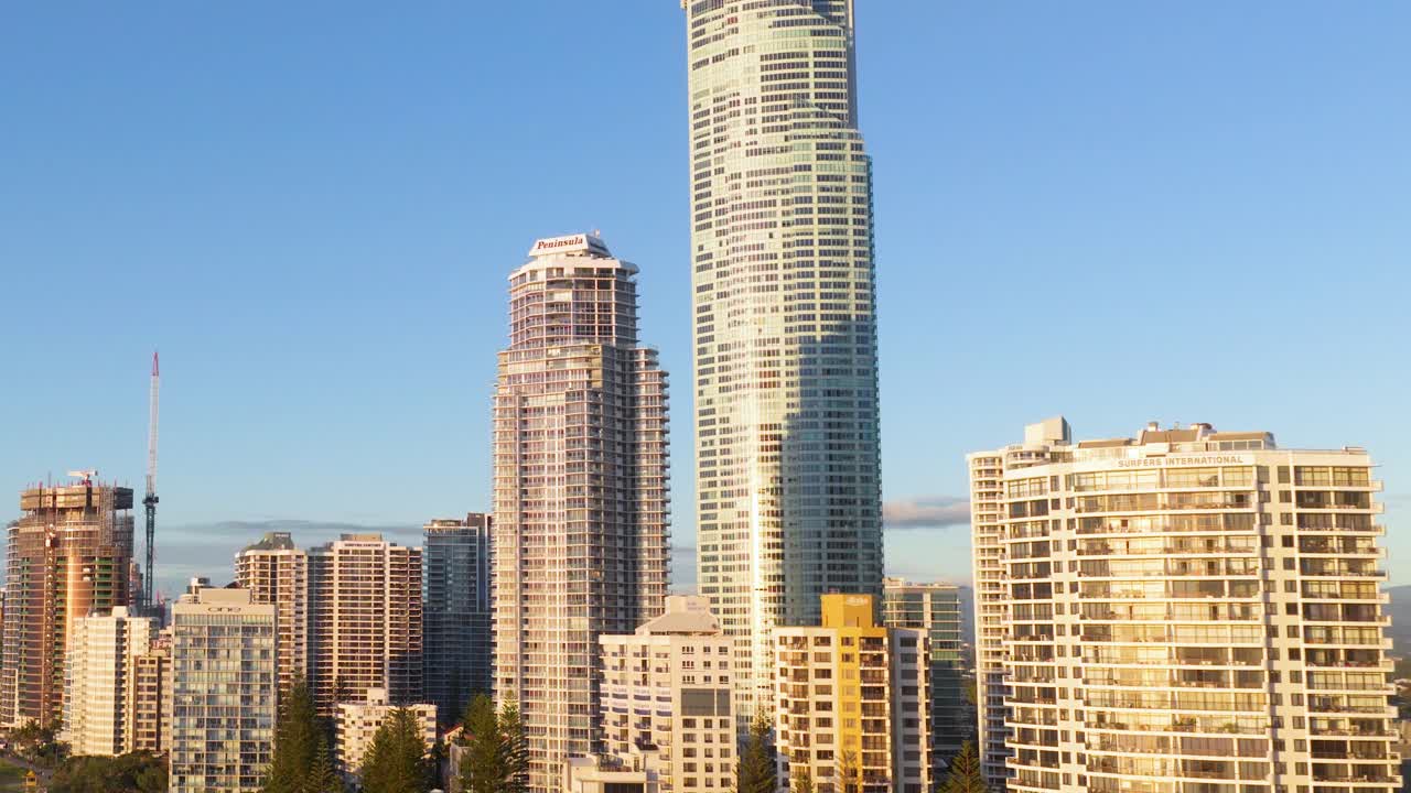 Aerial view of Gold Coast skyscrapers under clear blue skies, showcasing modern architecture and coastal beauty in bright sunlight