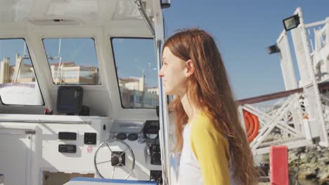 Side-view-of-a-teenage-Caucasian-girl,-enjoying-her-time-on-a-boat-harbor-side