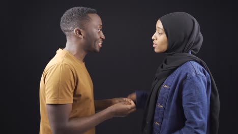 african muslim couple arguing, fighting and judging each other on black background.