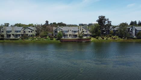 pull back shot from remarkable house cottages built on quite lagoon of san mateo, california