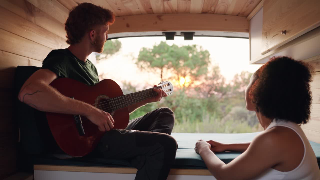 Couple enjoying music in a van during sunset