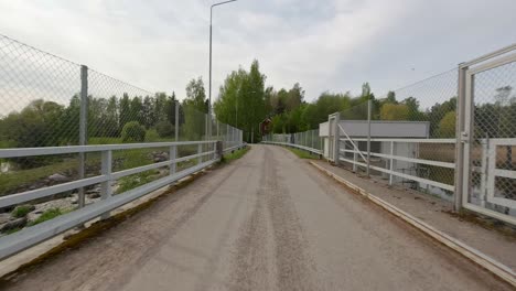 the car drives across a bridge, passing underneath it where water flows