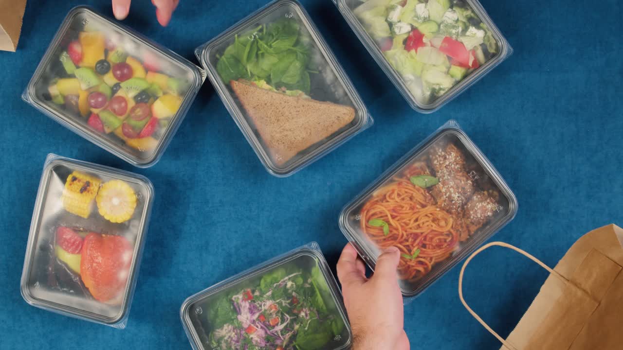 Hands Unpacking Healthy Prepared Meals from Delivery Bags