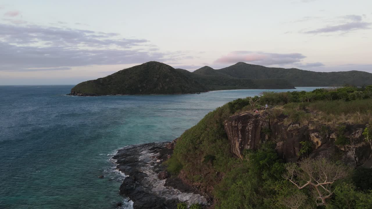 una pareja disfrutando de una puesta de sol romántica desde un punto de vista sobre el acantilado en la isla de drawaqa