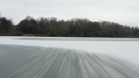 drone aerial footage of a 4k drone flying very close over a frozen lake in germany