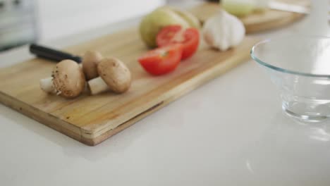 Vegetables-and-garlic-on-wooden-chopping-board-in-kitchen