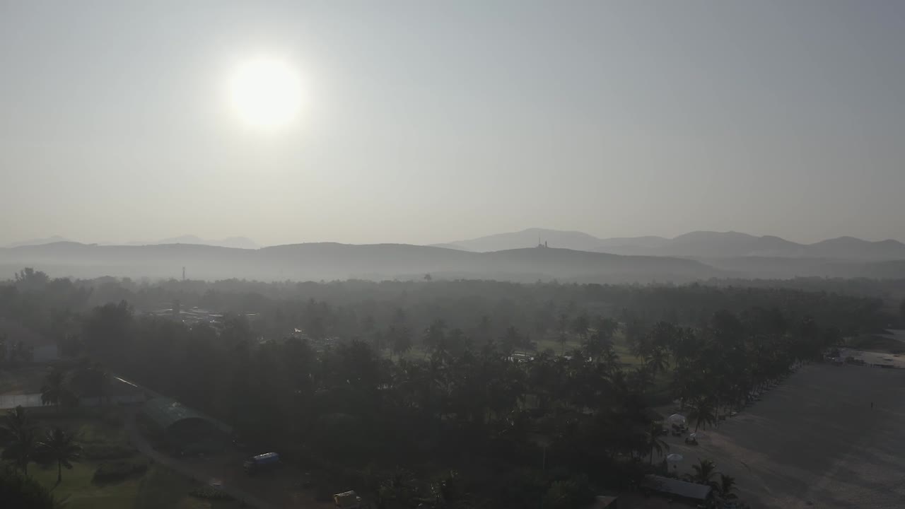 Aerial view of a misty sunrise over rolling hills and a rural townscape in Da Lat, Vietnam, capturing the serene atmosphere and scenic beauty of the countryside