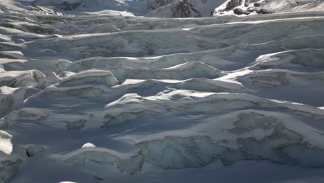 vista aérea: hielo azul que compone un glaciar en los alpes suizos en invierno