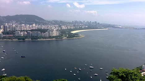 Lapso-De-Tiempo-Con-Barcos-Entrando-Y-Saliendo-Del-Puerto-Recreativo-De-Botafogo-En-Río-De-Janeiro-Formando-Patrones-En-El-Agua-Con-El-Centro-De-La-Ciudad-Al-Fondo