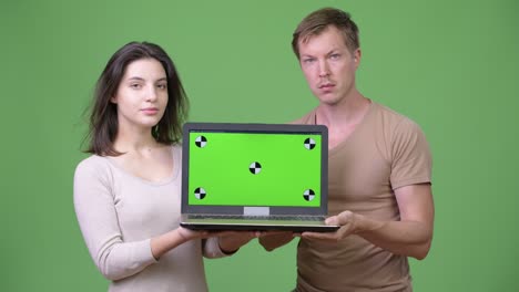 young couple showing laptop together