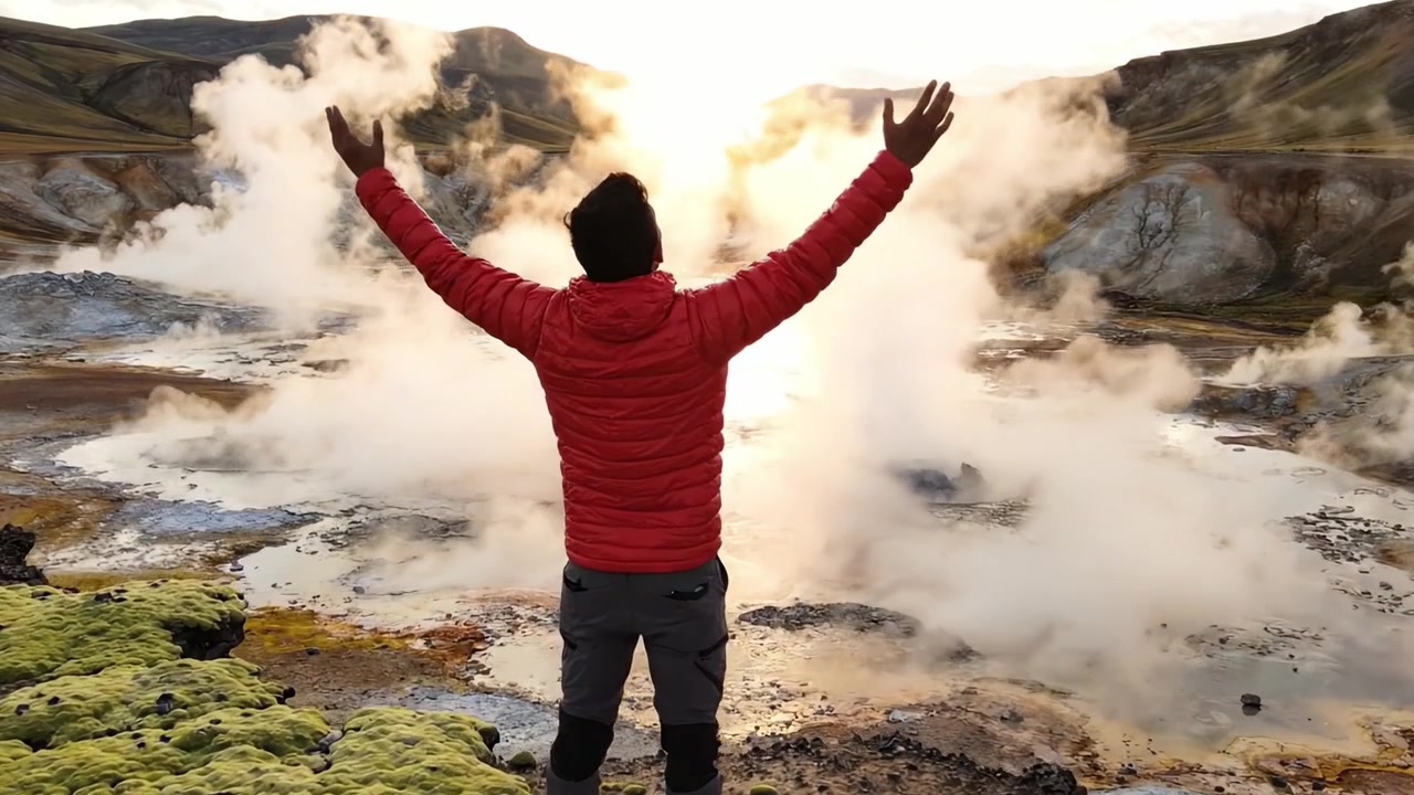 Una figura solitaria contempla los impresionantes paisajes geotérmicos, rodeada de vapor y colores vibrantes, capturando la esencia de la energía pura y la belleza de la naturaleza.