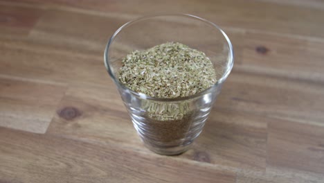 Panning-shot-of-dried-oregano-sitting-in-a-jar