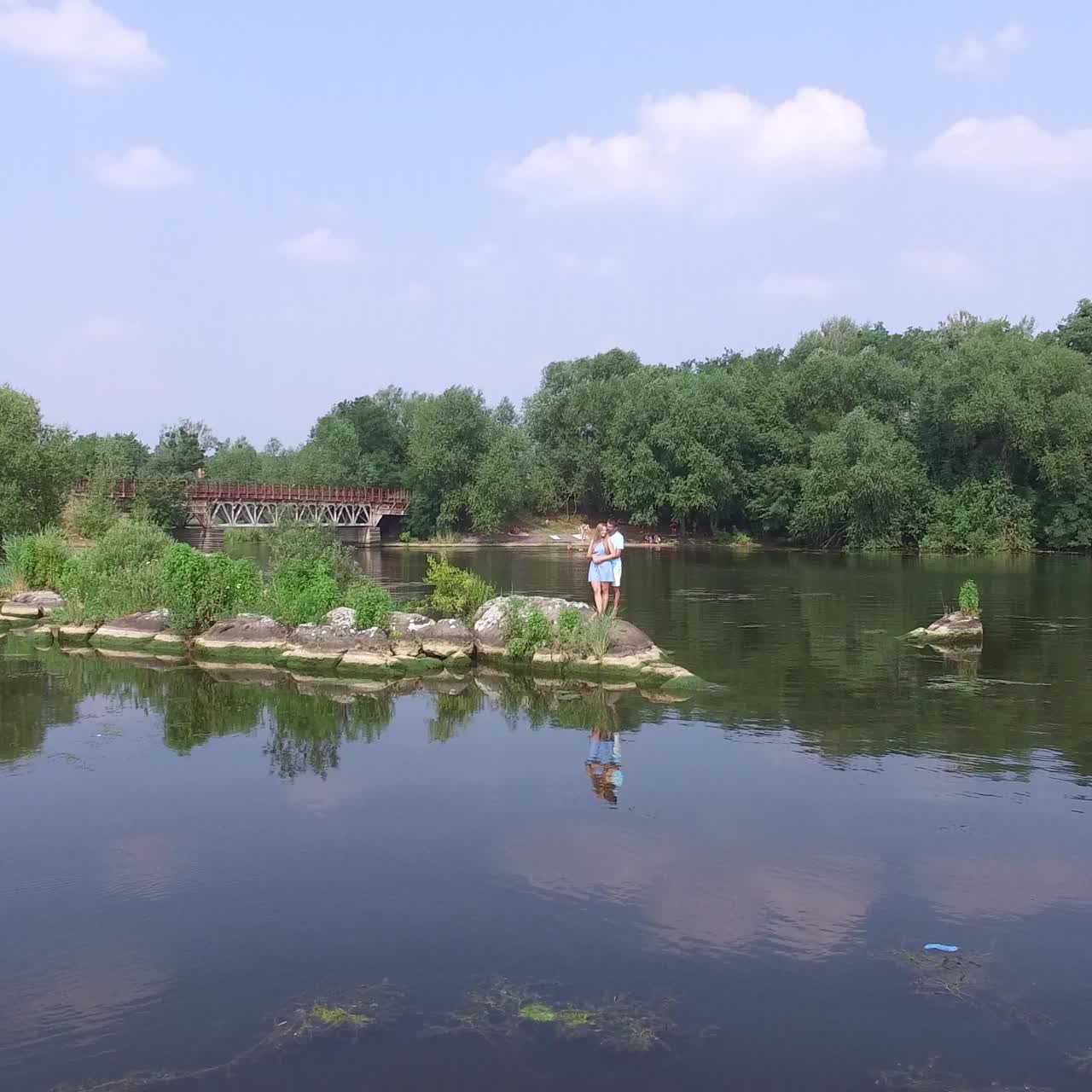 una pareja joven descansando en el río.