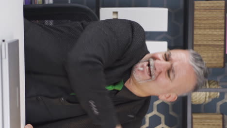 video vertical del hombre de negocios que ve malos eventos en la computadora portátil se enoja.