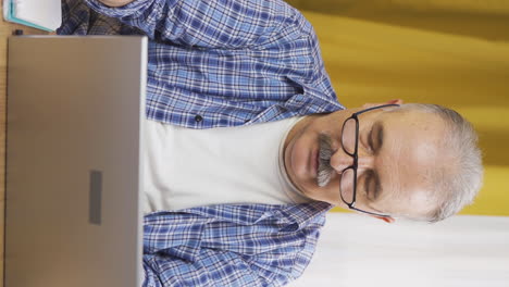 Vertical-video-of-Old-man-shopping-from-laptop.