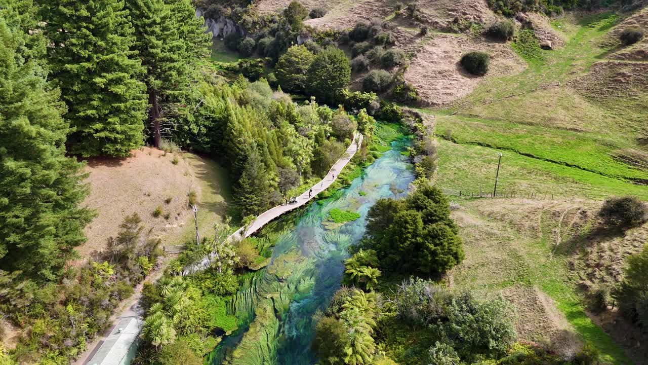 Un drone 4K sorvola Blue Springs in Nuova Zelanda, mettendo in risalto il fiume cristallino e la lussureggiante foresta circostante. Le acque pittoresche e il verde intenso creano una vista cinematografica e rilassante.