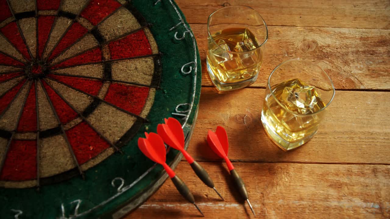 나무 테이블에 다르트와 위스키 4k