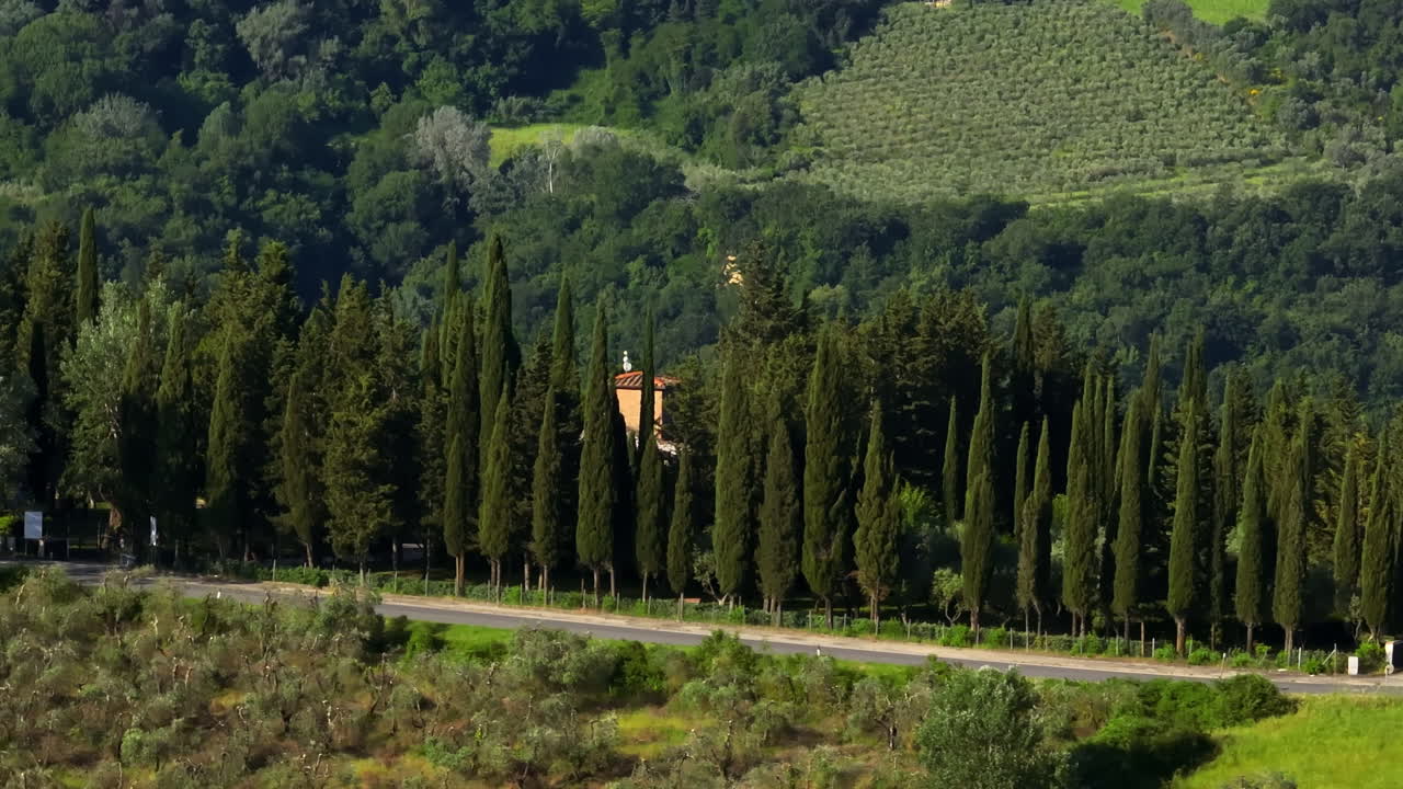 Aerial view of layers with cypress trees and rural fields of Tuscany, Italy