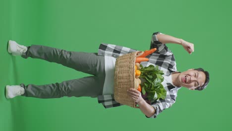 hombre feliz sosteniendo una canasta de verduras frescas
