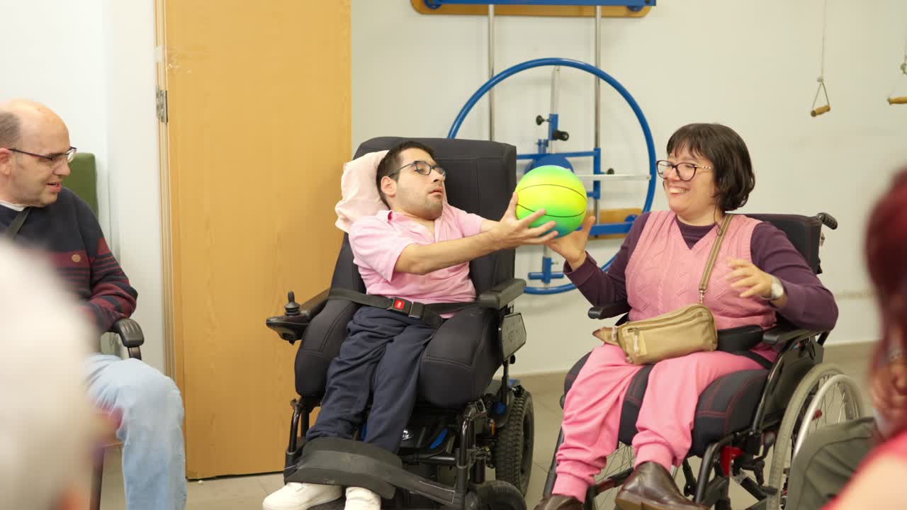 Disabled Adults in Wheelchairs Playing Ball During Therapy Session