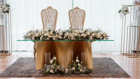 elegant wedding sweetheart table with gold accents and white floral arrangements