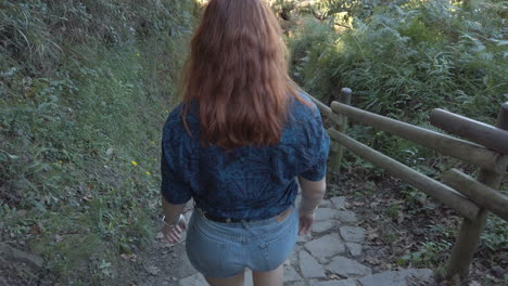 a woman walking on a forest trail