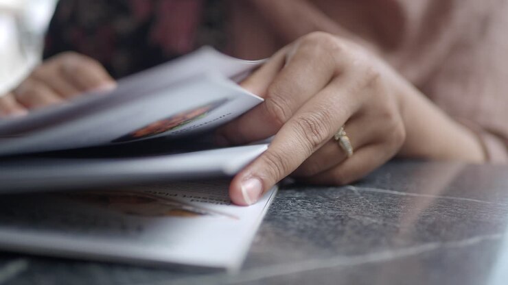 A woman reads the menu at a restaurant.
