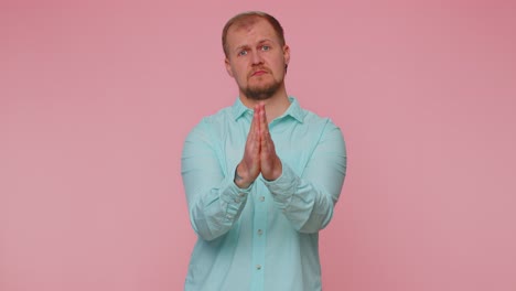 trendy young adult man praying looking upward and making wish asking god for help begging apology