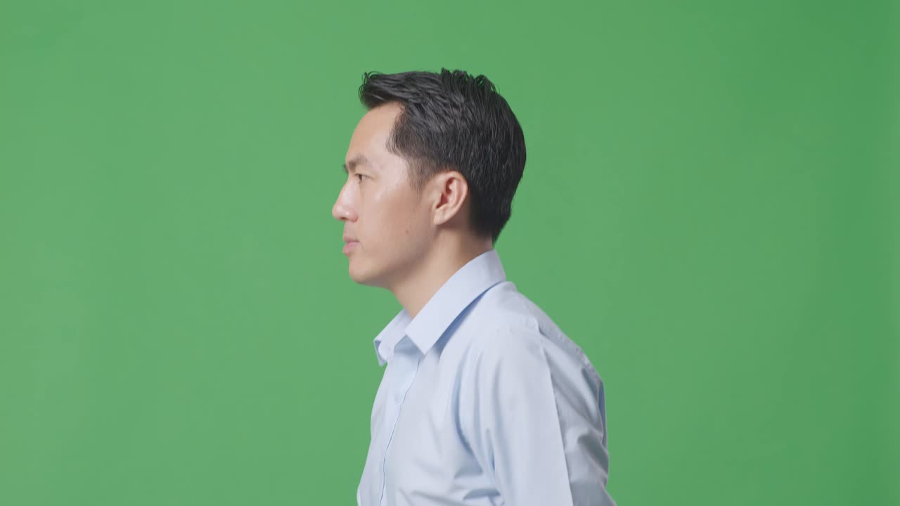 Side View Close Up Of Asian Business Man Walking On Green Screen Background In The Studio