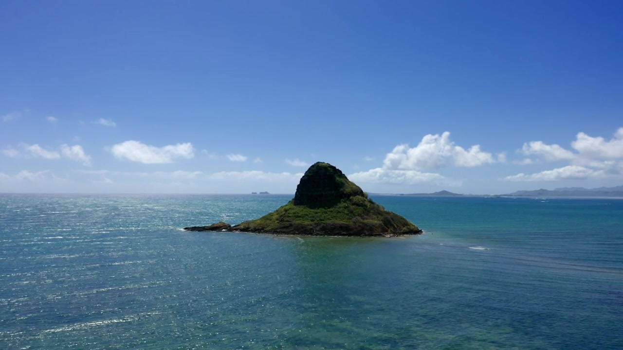 Die Insel Mokolii oder Chinaman's Hat, umgeben von klarem, blauem Wasser vor der Küste des Kualoa Regionalparks, mitten im offenen Ozean, eine einsame Schönheit.