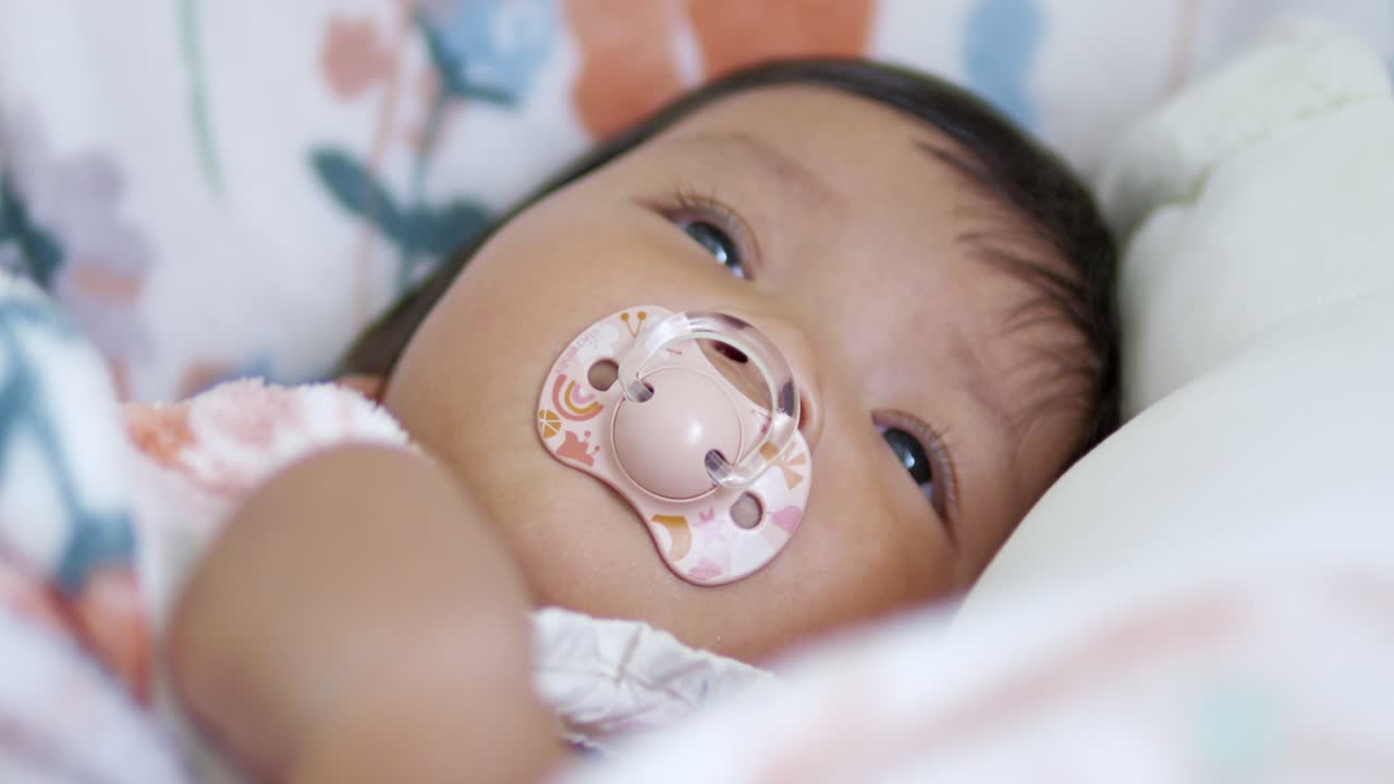A serene moment capturing a baby with a pacifier showcasing tranquility and innocence at home.