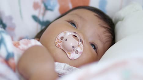 A serene moment capturing a baby with a pacifier showcasing tranquility and innocence at home.
